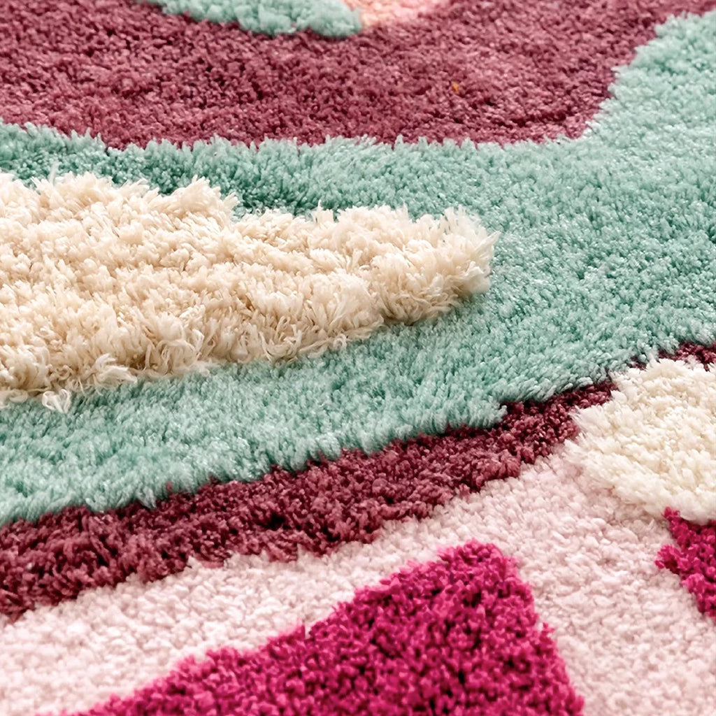 Close up of Willa 3D high-low tufted rug texture with aqua, cream, berry and pale pink raised colour sections