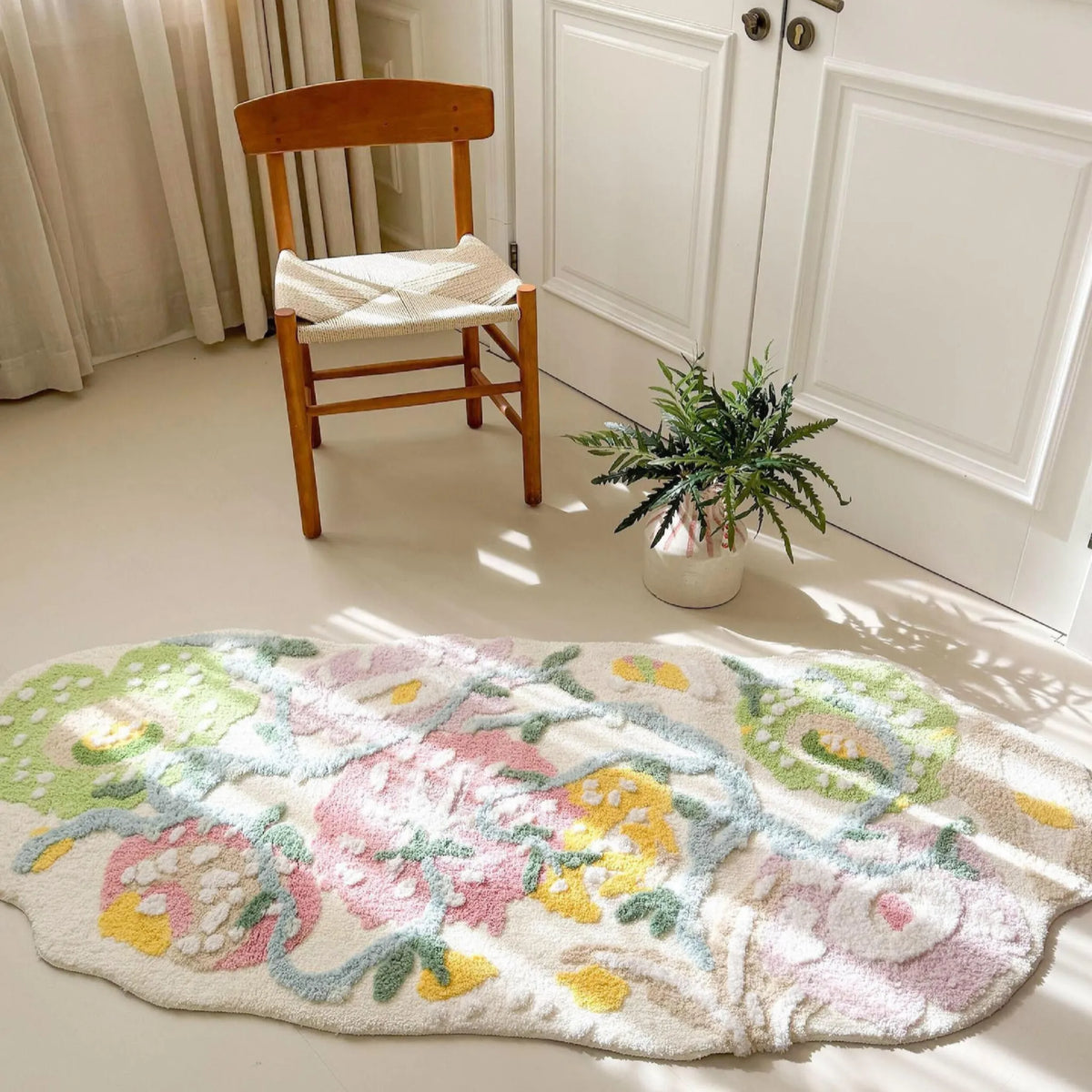 Housenfriends Celia pastel floral irregular runner rug with pink, green and yellow flowers beside a wooden chair in a sunlit room.