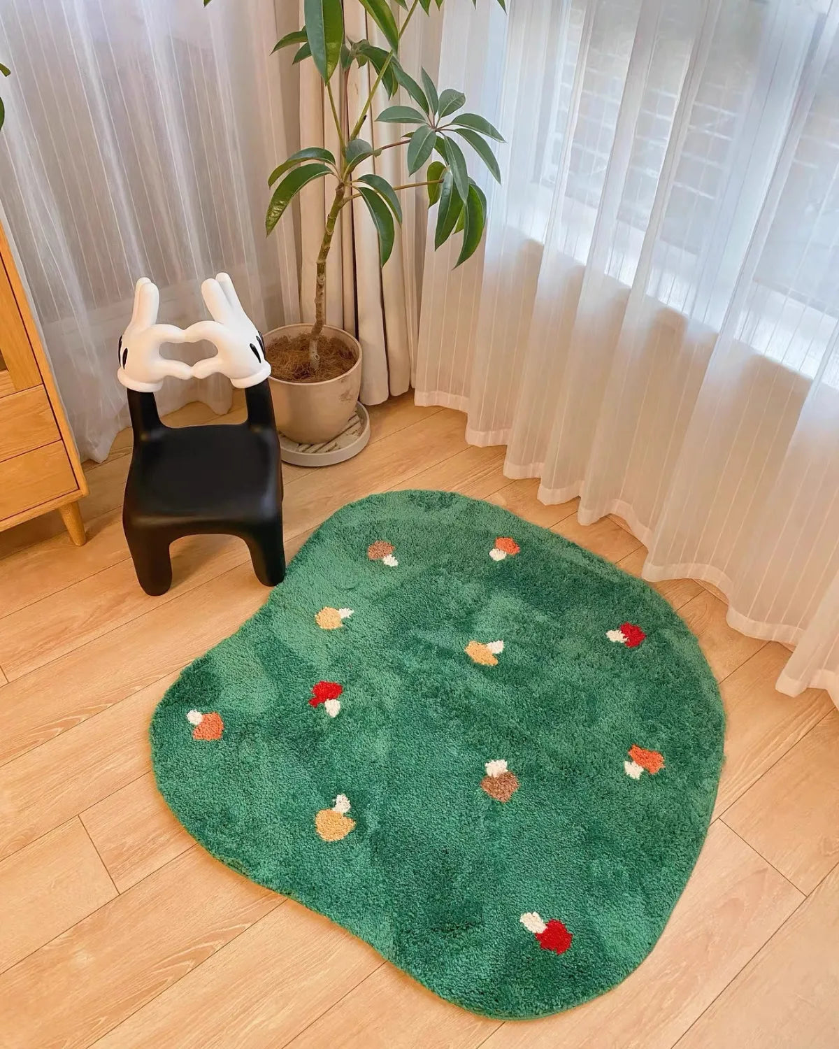 Housenfriends Elora moss green round mushroom tufted rug beside a chair in a bright reading nook, 100 × 100 cm.