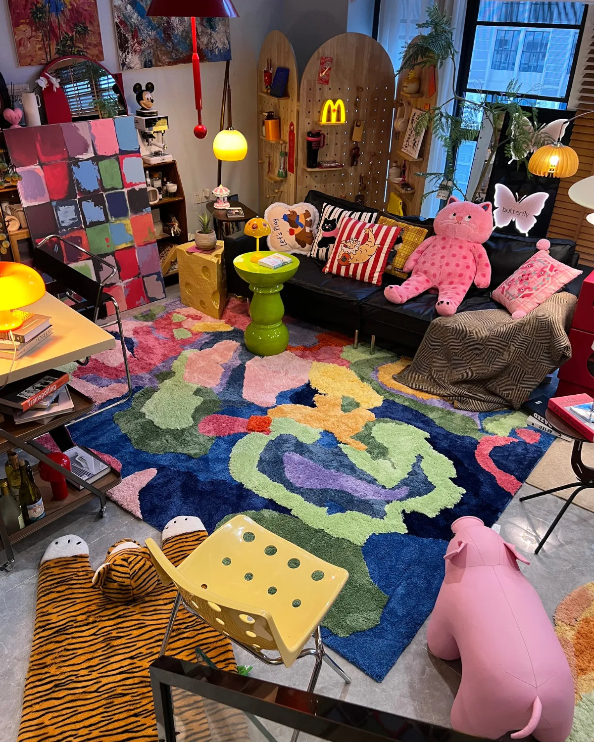 Housenfriends Freya multicoloured abstract floral tufted rug in a maximalist living room with a black sofa and colourful decor.