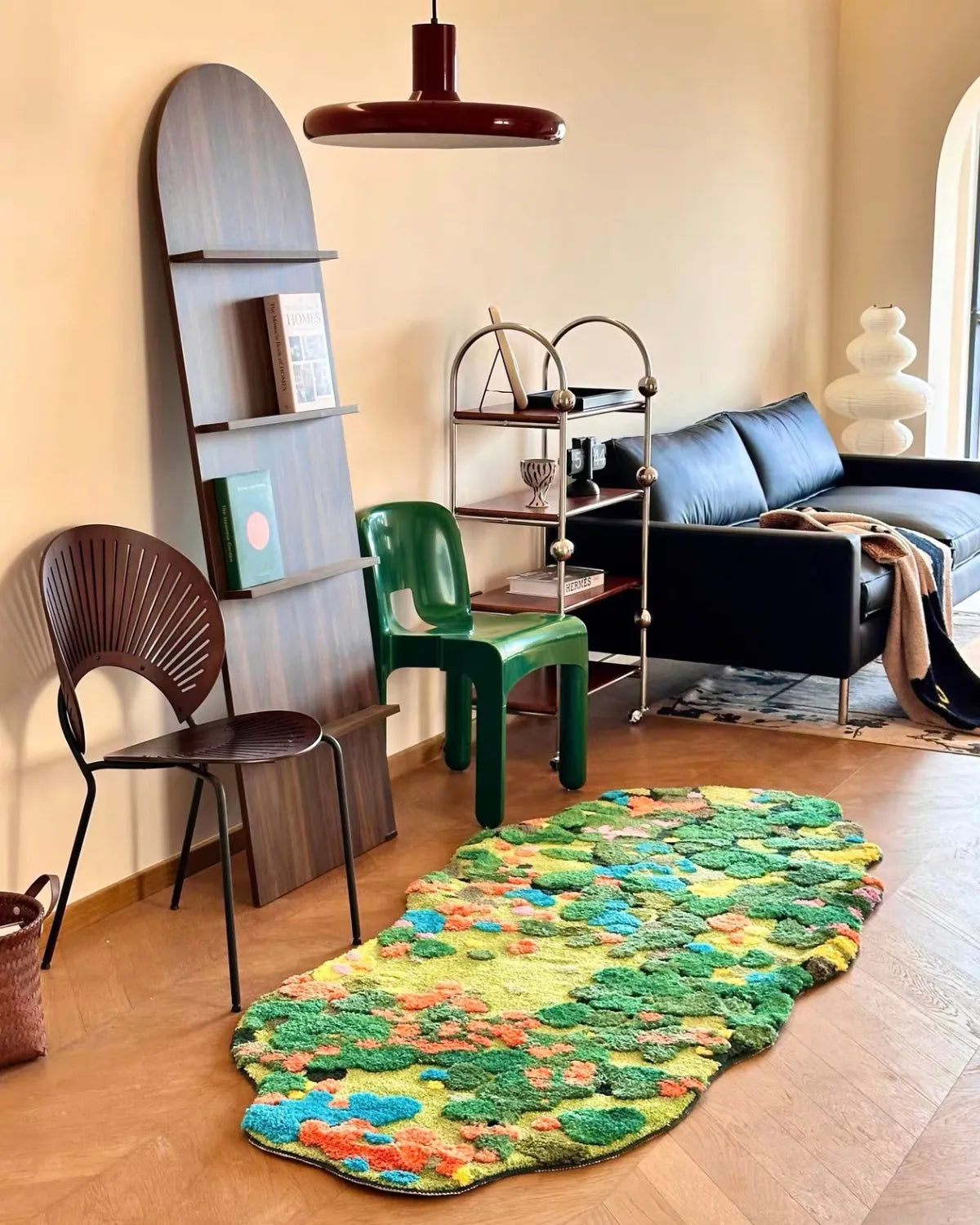 Housenfriends Merryn Green Moss Garden rug beside a blue sofa in a retro-inspired eclectic living room, 100 × 240 cm.