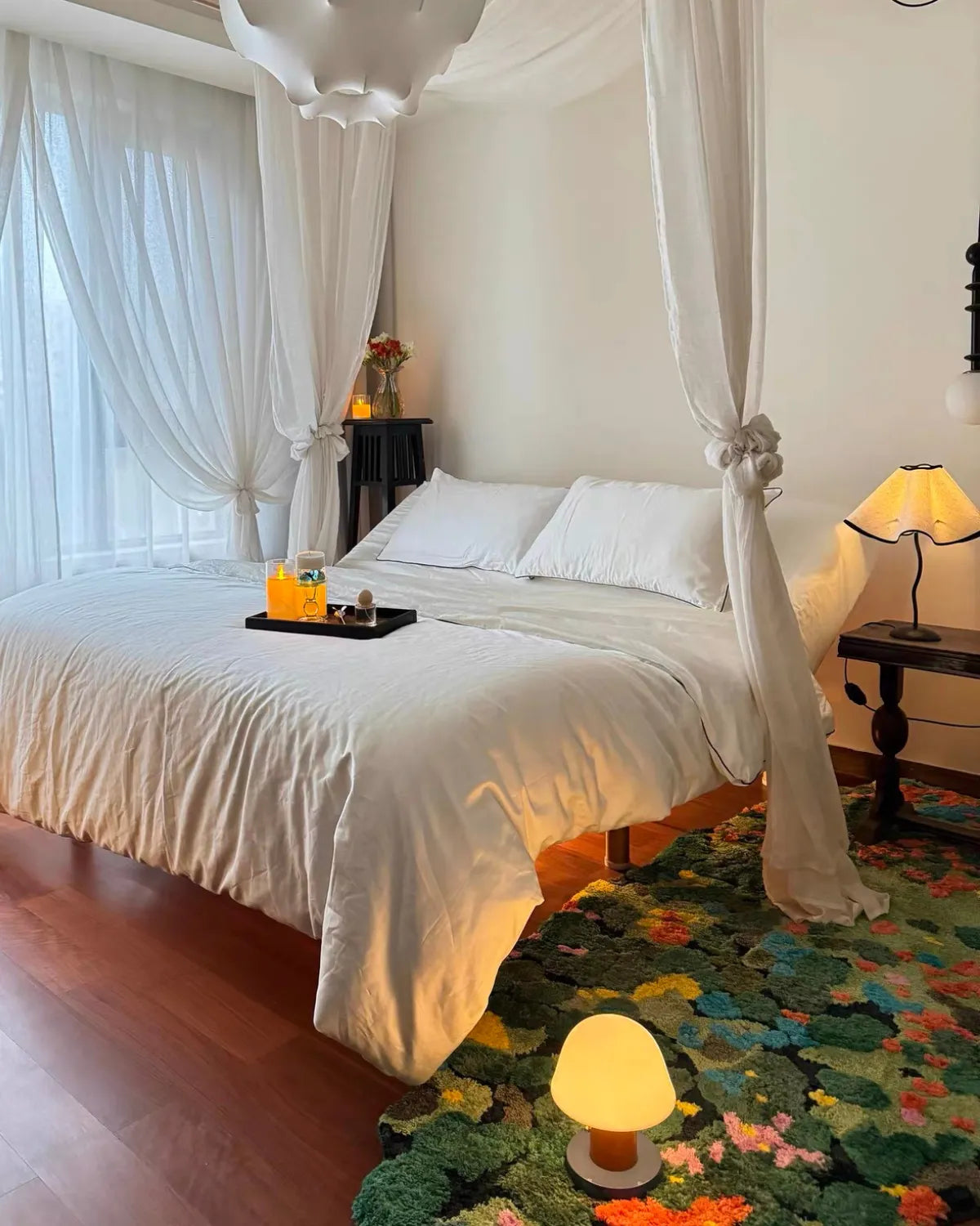 Housenfriends Merryn Green Moss Garden rug beside a canopy bed and bedside table in a softly lit bedroom, 100 × 240 cm.