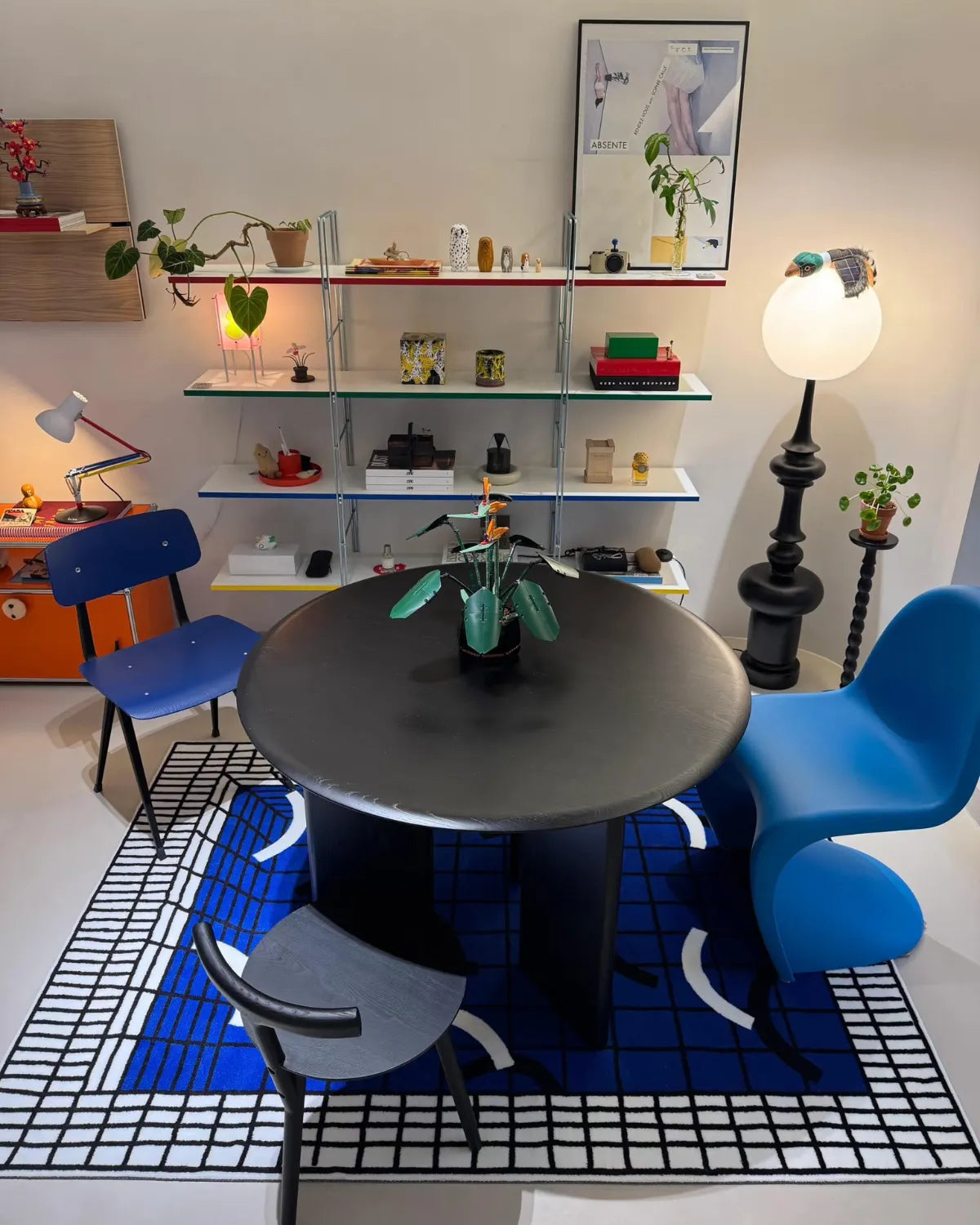 Housenfriends Poolside Blue White Grid Modern Graphic Rug beneath a round dining table, 80 × 120 cm.
