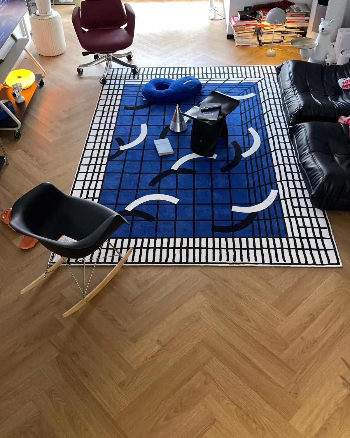 Housenfriends Poolside Blue White Grid Modern Graphic Rug in an eclectic living room with a black leather sofa, 140 × 200 cm.