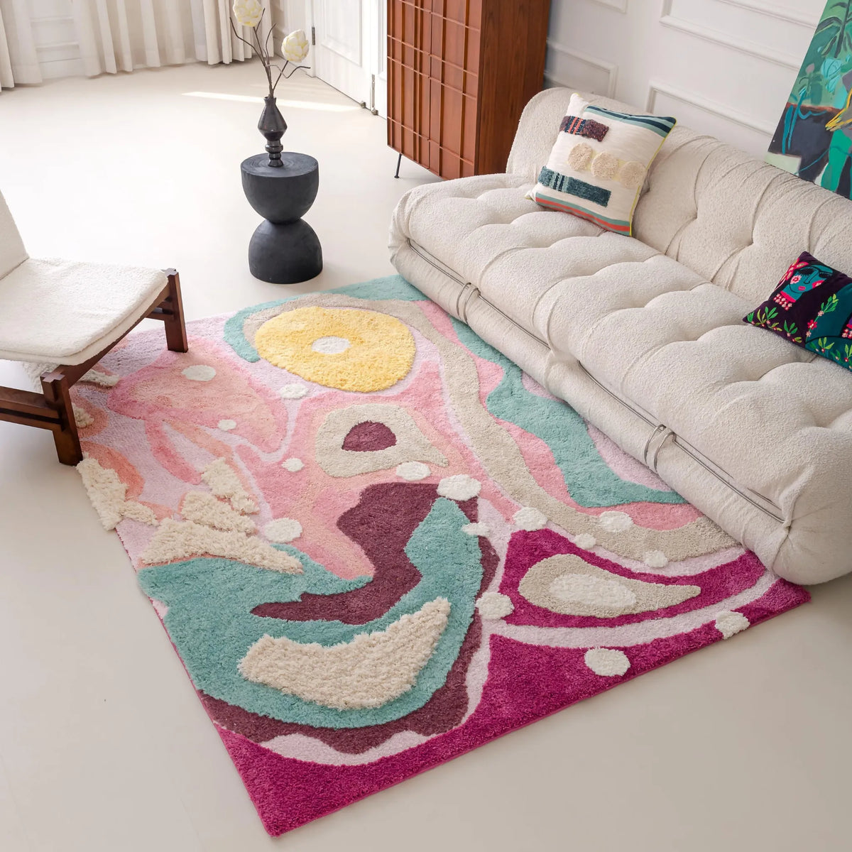 Housenfriends Willa pastel abstract swirl rug beside a cream sofa in a bright contemporary living room.