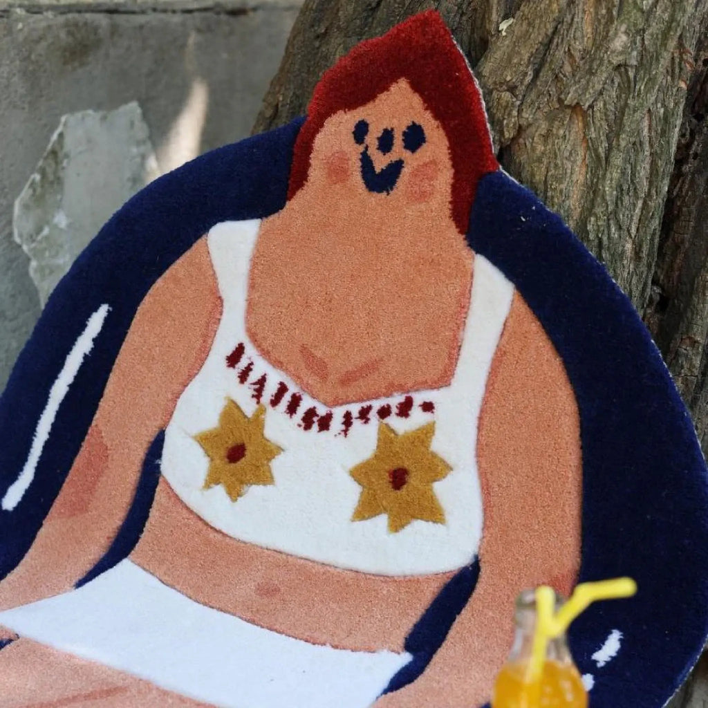 Close-up of Housenfriends June White Swimsuit Navy Blue Swim Ring Swimming Girl Body Art Tufted Rug, showing her red hair, smiling face and yellow floral details.